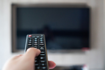 hand holding remote control point to television