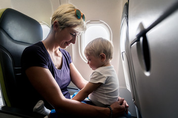 Mom spending time with her one year old baby boy during flight