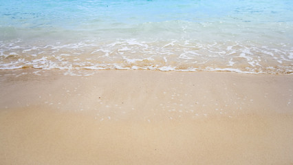 Fototapeta na wymiar Summer background of blue sea wave and brown beach sand 