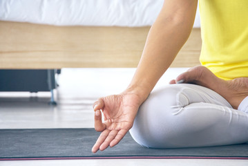 Fototapeta premium Close up woman 's hand practice yoga lotus pose to control meditation and healthy relax, lifestyle concept.