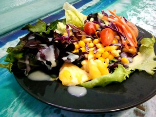 Salad of colorful fruits and vegetables in a black dish. Very appetizing.