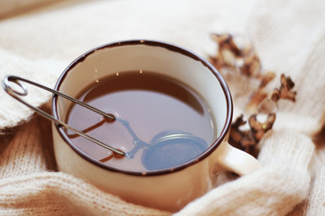 cup of ten and knitted beige sweater