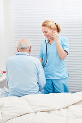 Obraz na płótnie Canvas Nurse listens to patient with stethoscope