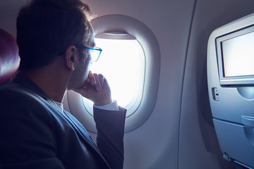 Man looking through a modern airplane window.