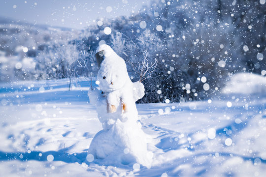 Snowman on a winter day against the background of the forest and snow