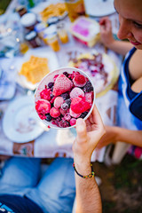 People making a picnic with sweet waffle and pancaces in the garden.