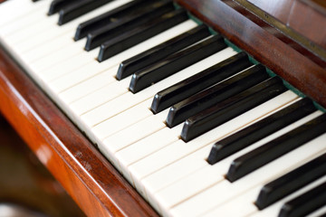 Old brown piano close-up. The keys of an old vintage piano