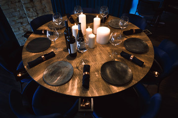 Fototapeta na wymiar Table with wine, glasses, candles and plates