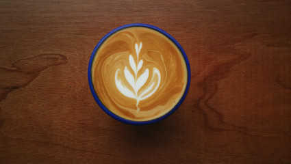 a cup of latte art coffee on wooden background                              
