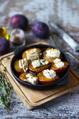 Keto snack. Baked plums with feta cheese and thyme. Keto friendly. Selective focus. Macro.