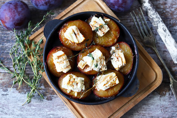 Keto snack. Baked plums with feta cheese and thyme. Keto friendly. Selective focus. Macro.