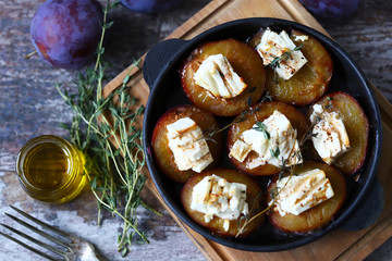 Keto snack. Baked plums with feta cheese and thyme. Keto friendly. Selective focus. Macro.