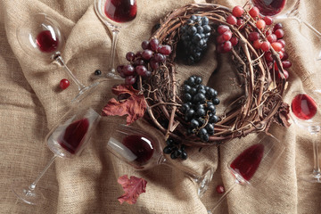 Red wine and grapes on a table covered with burlap.