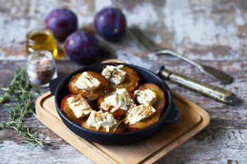 Keto snack. Baked plums with feta cheese and thyme. Keto friendly. Selective focus. Macro.