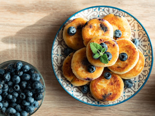 Plate with tasty fluffy pancakes with blueberries, honey