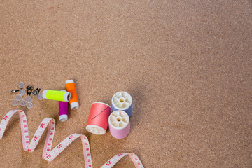 Fototapeta na wymiar Dressmaking equipment, thread needle placed on a brown plywood floor.