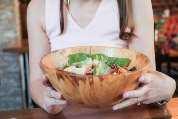 Portrait of wellness healthy women with slad bowl in cafe