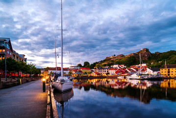 View of the illuminated houses and yachts with Fredriksted fortress at the background in Halden,...