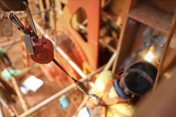 Top view welder wearing safety helmet fall arrest harness using fall prevention system red fall...