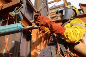 Rope access welder maintenance abseiler wearing fall safety body harness welding helmet protective...