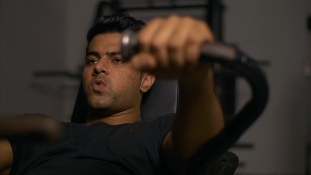 A young and fit boy doing abdomen crunches in the gym. 