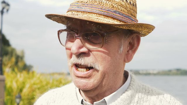 Closeup portrait of a very grumpy grouchy senior man. Who is arguing with someone