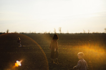 happy family is walking along the wheat field at sunset. The concept of family and love.