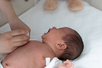 Mother changing her baby's clothes