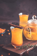 Autumn or winter sea buckthorn drink. Sea Buckthorn tea, selective focus. Still life, food and drink, seasonal and holidays concept. Autumn hot beverage in a glass