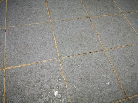 Ingrained dirt stuck on the bathroom floor.