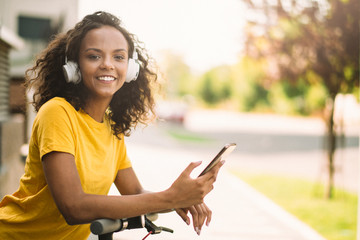 African girl driving electric scooter using phone