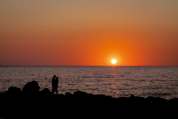 sunset. sunset sea. Silhouettes of a hugging couple in love.