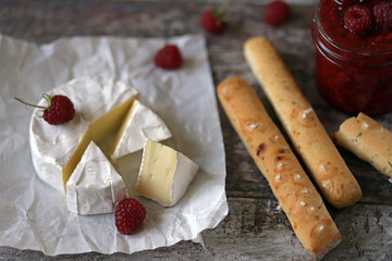 Camembert cheese with raspberry sauce and grossini sticks. Keto friendly. Italian mood. Selective focus. Macro.