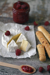 Camembert cheese with raspberry sauce and grossini sticks. Keto friendly. Italian mood. Selective focus. Macro.