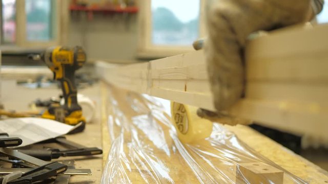 Artel Clip 27The master in the carpentry workshop glues the boards with special glue before pressing