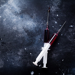 Syringe with blood on old concrete background. Square image. Top view.