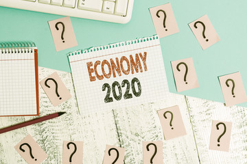 Text sign showing Economy 2020. Business photo showcasing State of wealth and resources of a country in upcoming year Writing tools, computer stuff and math book sheet on top of wooden table