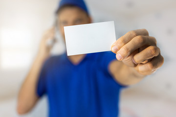 handyman services - worker showing blank business card and making a phone call