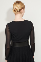 Cropped back view shot of a blond girl, posing on a white background. She is wearing black gown...