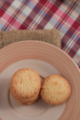 Round sweet cookies. Delicious dessert with high sugar and carbohydrate suitable for eating with milk and tea or coffee on color and white background with colorful placemat