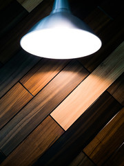 The background texture of a wooden wall under a shining lamp.
