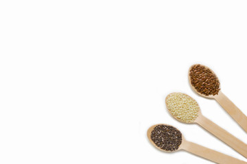 assorted seeds in wooden spoons isolated on white background, chia, linen sesame, healthy food supplements, super food, top view, flat lay