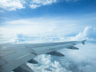 Airplane wing with sky Clouds in the background