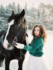 Fototapeta premium Woman winter portrait in snow forest. Film analog photography. Cold weather. Christmas time