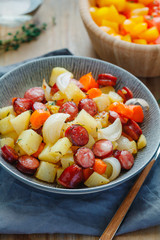 Roasted sausages with vegetables like potato, onion and carrot. Easy fast recipe for dinner or lunch.