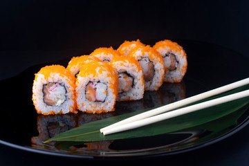 california rolls with crab sticks on black plate