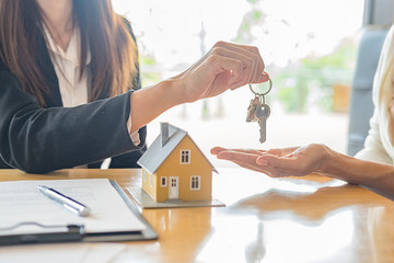 House model with agent and customer discussing for contract to buy, get insurance or loan real...