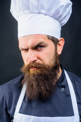 Professional approach to business. Bearded man in chef uniform. Professional serious man chef ready to cook new dish. Male chef, cook or baker in white hat and apron. Cooking, profession and business.