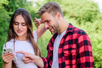 Fototapeta premium Do not peep. Buy online. Man picky jealous girlfriend messaging online. Internet dependence. Guy and girl nature smartphone. She always online. Mobile addicted. Social networks. Surfing internet