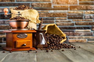 still life with coffee beans and old coffee mill on the wooden background,coffee grinder,coffee accessories brown clay cup vintage wooden mill and sack with beans scoop on old wood background - Powered by Adobe
